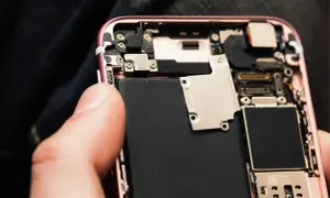 Wymiana baterii w iPhone 11: widok wnętrza telefonu z dużą czarną baterią.