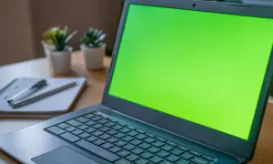 Zielony ekran laptopa, obok notatnik z długopisem. Czy to chromebook czy laptop?