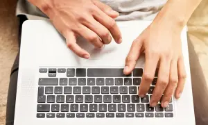Dłonie na klawiaturze laptopa HP. Dowiedz się, jak odblokować klawiaturę w laptopie HP, gdy przestanie odpowiadać.
