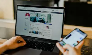 Osoba korzysta z laptopa z profilem na Facebooku, szukając informacji, jak odblokować aplikacje na Facebooku.