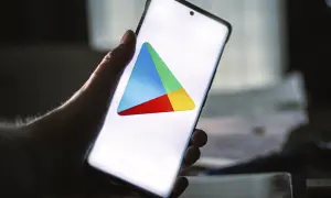 Dłoń trzyma smartfon z widocznym logo Sklepu Google Play.