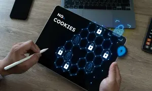 Tablet z napisem "COOKIES" i ikonami kłódek, symbolizujący jak usunąć dane przeglądarki. Obok leży telefon i kalkulator.