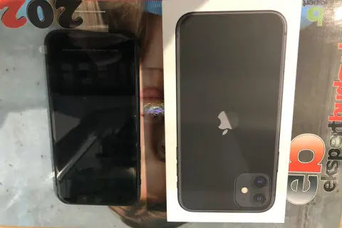 Czarny iPhone 11 w pudełku, obok niego drugi taki sam. Szukasz, gdzie najtaniej kupić ten model?