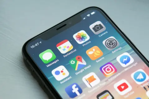 Ekran iPhone z ikonami aplikacji. Dowiedz się, jak wyłączyć aplikacje w tle iPhone, aby oszczędzać baterię.