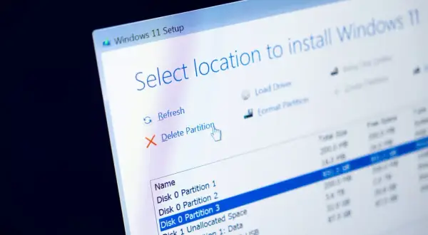 Ekran instalacji Windows 11. Widoczna opcja "Usuń partycję", kluczowa, gdy chcemy sformatować laptop.