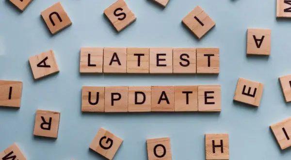 Drewniane klocki z literami tworzą napis "LATEST UPDATE". Dowiedz się, jak zaktualizować sterowniki w komputerze, aby cieszyć się najnowszymi funkcjami.