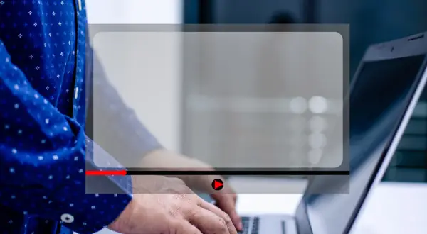 Osoba pisze na laptopie, a na ekranie widoczny jest odtwarzacz wideo. Dowiedz się, jak zmniejszyć ekran w przeglądarce, aby wygodniej oglądać.