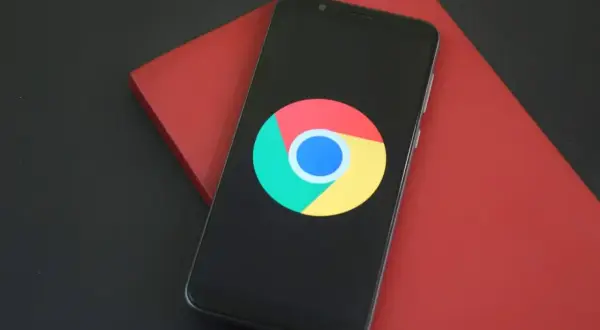 Telefon z logo Chrome. Dowiedz się, jak wyczyścić przeglądarkę Chrome w telefonie, aby przyspieszyć działanie urządzenia.