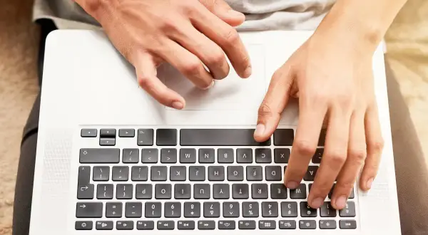 Dłonie na klawiaturze laptopa HP. Dowiedz się, jak odblokować klawiaturę w laptopie HP, gdy przestanie odpowiadać.
