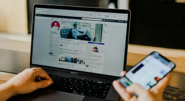 Osoba korzysta z laptopa z profilem na Facebooku, szukając informacji, jak odblokować aplikacje na Facebooku.