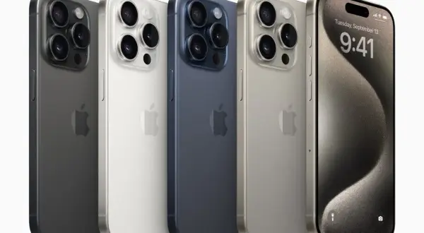Pięć iPhone'ów w różnych kolorach: grafitowy, biały, granatowy, złoty i jeden z włączonym ekranem, prezentujący datę i godzinę.