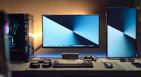 Stacja robocza z trzema monitorami, klawiaturą, myszką i komputerem PC. Idealna do pracy i rozrywki, pokazuje, jak podłączyć 3 monitory do laptopa.