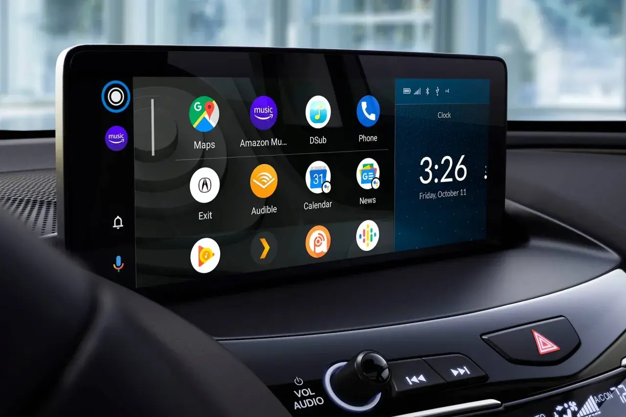 Ekran samochodu z ikonami aplikacji, zegarem i datą. Dowiedz się, jak zaktualizować Android Auto, aby korzystać z najnowszych funkcji.
