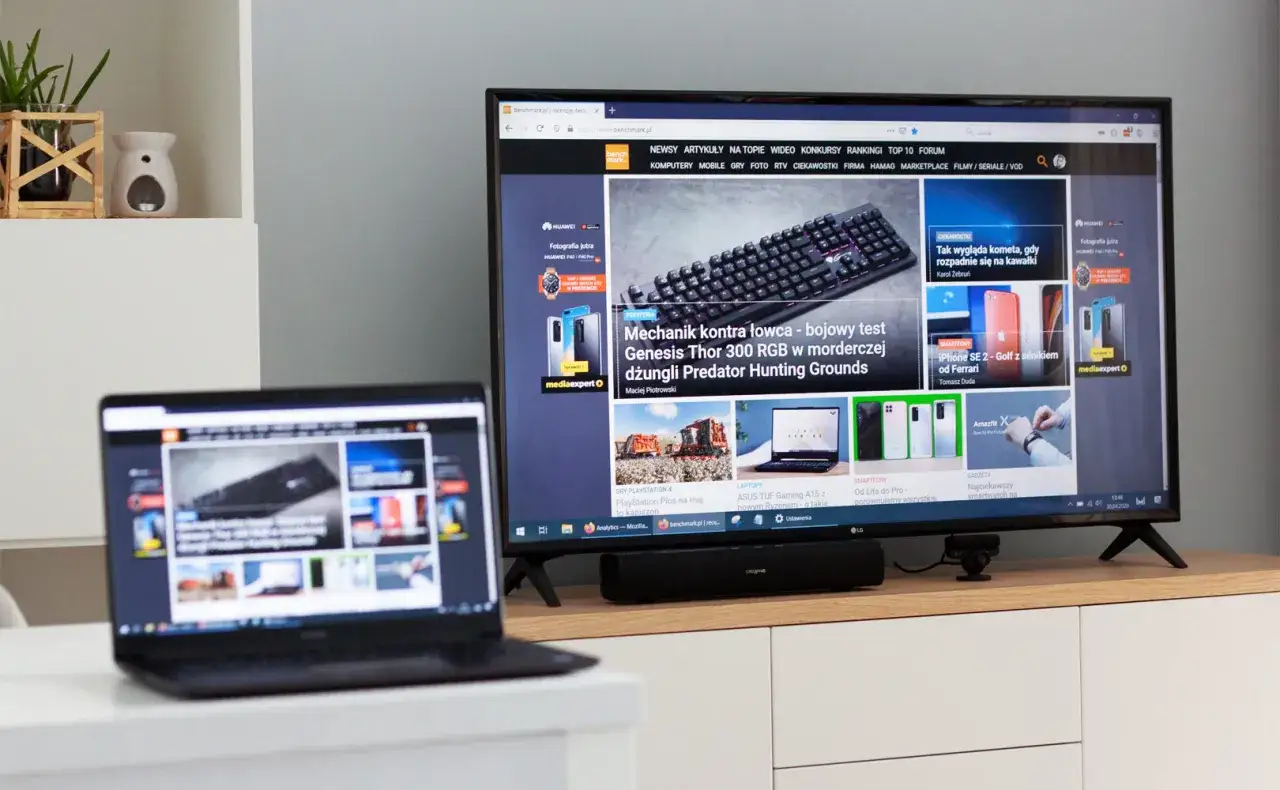 Jak przenieść obraz z laptopa na telewizor bezprzewodowo? Na ekranie telewizora widać stronę z artykułami technologicznymi, podobną do tej na laptopie.
