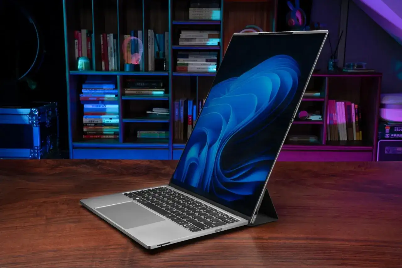 Elegancki laptop na drewnianym biurku, z niebieskim tłem na ekranie. Zastanawiasz się, ile kosztują laptopy?