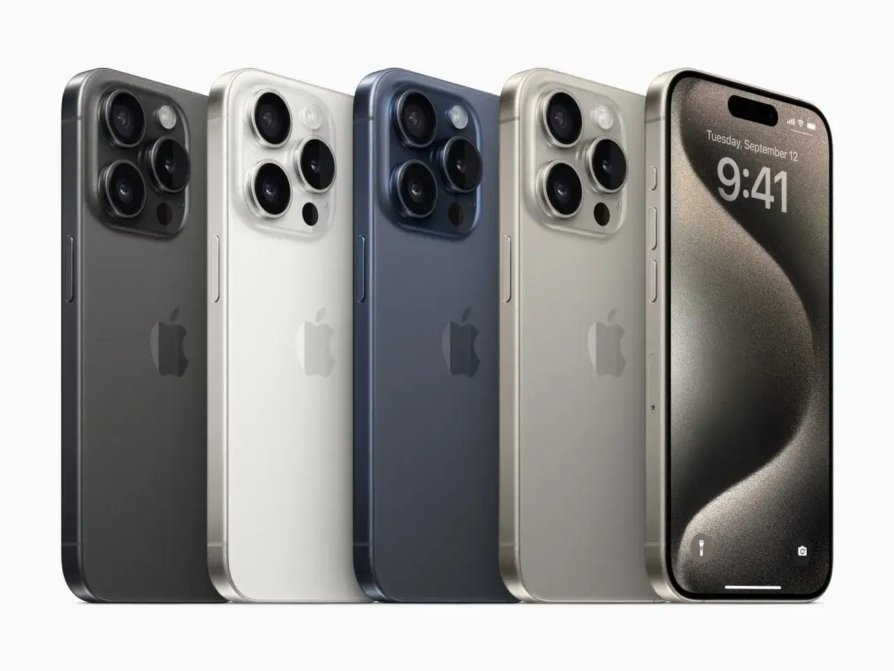 Pięć iPhone'&oacute;w w r&oacute;żnych kolorach: grafitowy, biały, granatowy, złoty i jeden z włączonym ekranem, prezentujący datę i godzinę.