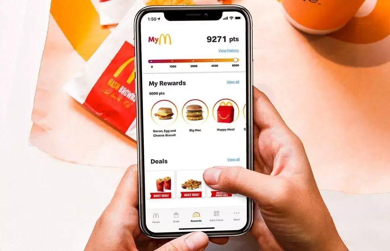 Chcesz wiedzieć, jak ściągnąć aplikację McDonald's na telefon? Na ekranie widzisz aplikację z nagrodami i ofertami.