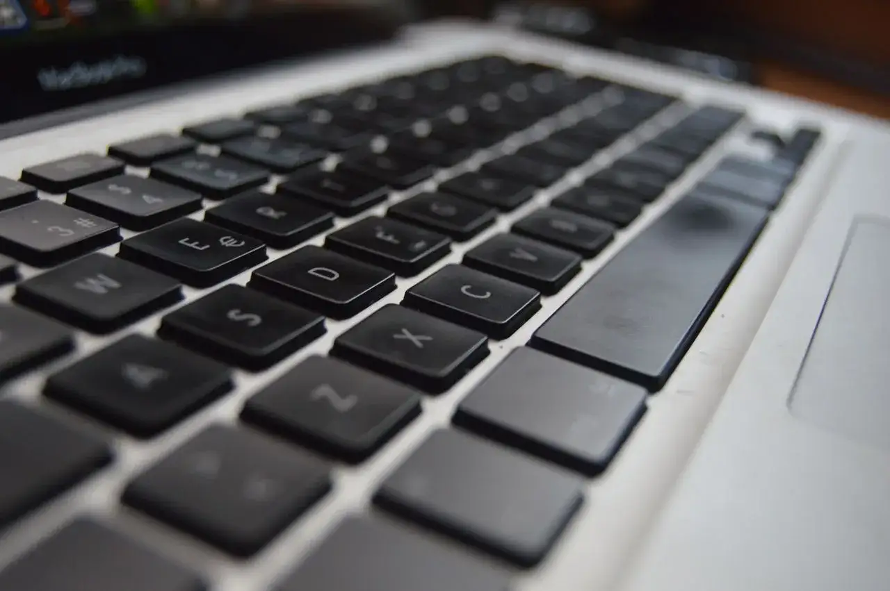 Zbliżenie na klawiaturę laptopa. Widoczne klawisze z literami i cyframi. Dowiedz się, jak przywrócić ustawienia klawiatury w laptopie.