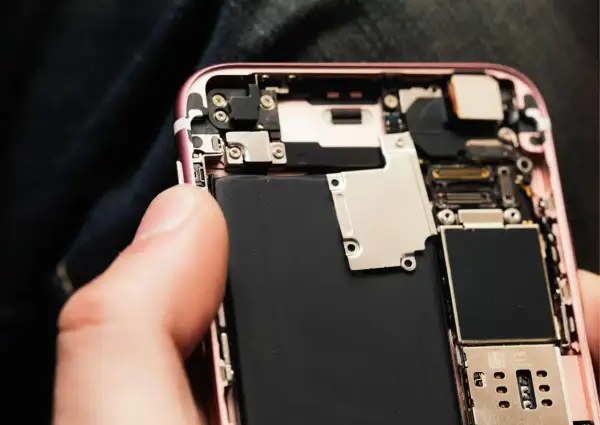 Wymiana baterii w iPhone 11: widok wnętrza telefonu z dużą czarną baterią.