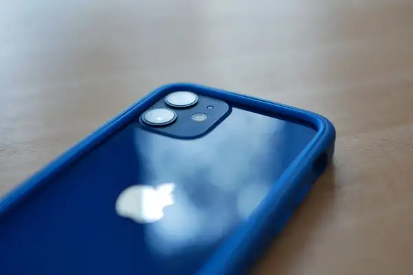 Niebieski iPhone 12 mini w etui. Zastanawiasz się, ile kosztuje iPhone 12 mini? Ten model oferuje świetne funkcje w kompaktowym rozmiarze.